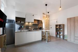 a kitchen with white cabinets and a stainless steel refrigerator at LittleSuiteBande NERE in Milan