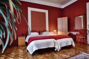 um quarto com uma cama grande e paredes vermelhas em Bed and Breakfast "Caffe-caffe" em Kikinda
