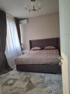 una camera da letto con un letto e un lampadario di Квартира в Ташкенте a Yakkasaray