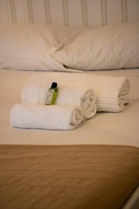 una pila di asciugamani appoggiata sopra un letto di Sogni in Volta a Monopoli