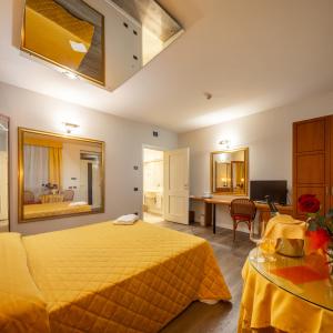 Hotel Motel Sporting في Montodine: غرفة فندق بها سرير أصفر ومكتب +28 صورة