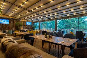 Hotel Orpheus - Casino and SPA في بامبوروفو: مطعم به طاولات وكراسي ونوافذ كبيرة