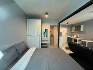 une chambre avec un grand lit et une cuisine dans l'établissement Zcap3 condo central Phuket, à Ban Rangeng