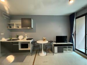 une cuisine avec une table, un évier et un comptoir dans l'établissement Zcap3 condo central Phuket, à Ban Rangeng