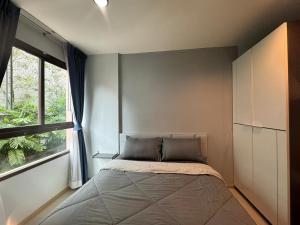 une chambre avec un lit et une grande fenêtre dans l'établissement Zcap3 condo central Phuket, à Ban Rangeng