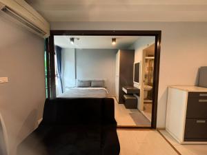 une petite chambre avec un lit et un miroir dans l'établissement Zcap3 condo central Phuket, à Ban Rangeng 2 autres photos