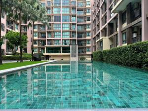 une piscine devant un grand bâtiment dans l'établissement Zcap3 condo central Phuket, à Ban Rangeng