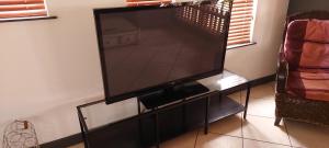 a large flat screen tv sitting on a stand at Belle-áme Self catering Accommodation in George