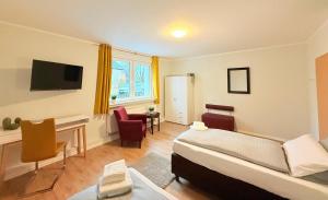 a room with a bed and a desk and chairs at Landhaus am Damme in Garbsen