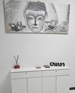 a painting of a statue on top of a white cabinet at Vittoria's rooms in Rome
