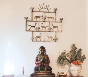a buddha statue on a table in front of a shelf at Casa em Miguel Pereira in Miguel Pereira