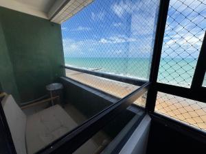 a room with a view of the beach from a window at Frente Mar in Natal