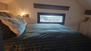 a bedroom with a bed with a television in it at Les pagotins de Garance, Chalet chaleureux Chat Gris, cosy et classé 3 étoiles in Métabief