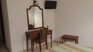 a bedroom with a desk with a mirror and a chair at Hotel Serantes in O Grove