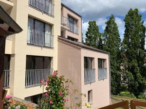 an apartment building with balconies and a bush at Les Aurores in Bitche