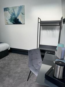 a room with a desk and a chair and a bed at The Station Hotel in Worksop