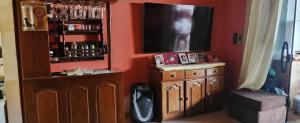 a living room with a television and a wooden cabinet at Casa da Gi Aluguel para COP 30 in Ananindeua