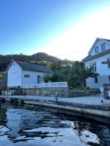 a couple of buildings next to a body of water at Hytte ved sjøen på Andabeløy in Flekkefjord