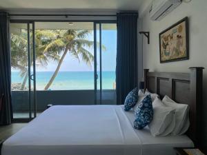 a bedroom with a bed with a view of the ocean at Villa Sea Queen in Ambalangoda