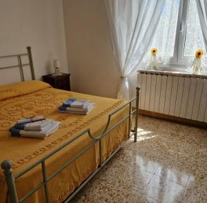 sypialnia z łóżkiem i ręcznikami w obiekcie B&B Mare e Monti w mieście La Spezia
