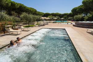 two people in a swimming pool at a resort at Club del Sole Orbetello Family Collection in Orbetello