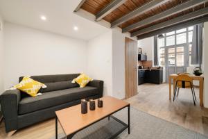 a living room with a couch and a table at L'Eden d'Elyse - Duplex premium- parking gratuit in Nancy