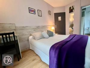 a bedroom with a large bed with a purple blanket at Alliance Hôtel Paris in Paris