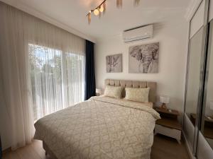 una camera da letto con un letto e una grande finestra di Lux 1BDR Four Season a Boghaz