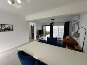 un soggiorno con tavolo bianco e sedie blu di Lux 1BDR Four Season a Boghaz