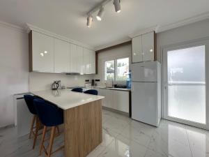 una cucina con armadi bianchi e sedie blu di Lux 1BDR Four Season a Boghaz