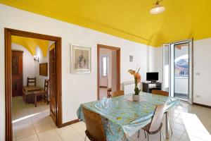 Casa bici sole e mare في سان لورينزو الماري: غرفة طعام مع طاولة وسقف أصفر