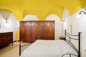 Casa bici sole e mare في سان لورينزو الماري: غرفة نوم بسرير وسقف اصفر