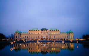 duży budynek z odbiciem w wodzie w nocy w obiekcie Deluxe apartment near hauptbahnhof w Wiedniu