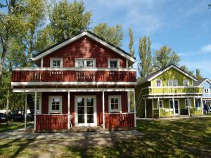 an old red house with a green house at Ferienwohnung im Ferienresort Kulkwitzer See Leipzig in Leipzig