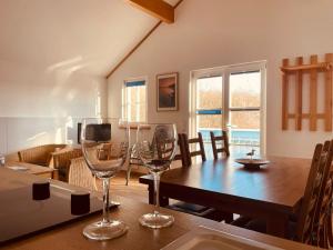 a dining room with a table and two wine glasses at Ferienwohnung im Ferienresort Kulkwitzer See Leipzig in Leipzig