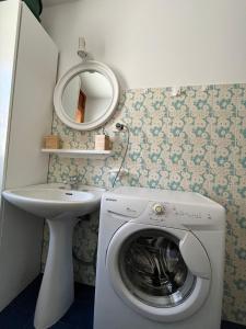 a washing machine in a bathroom with a mirror at Casa vacanze la Primula in Sauze d'Oulx