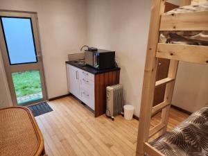 una stanza con un letto a castello e una scrivania con un forno a microonde di The Nightly Stay - Studio Cabin a Guildford