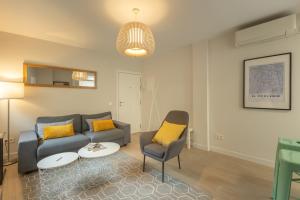 a living room with a couch and a chair at Charming Apartment with private patio at Plaza de España by OCityzen in Seville