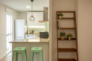 a kitchen with a counter and two stools at Charming Apartment with private patio at Plaza de España by OCityzen in Seville +14 photos