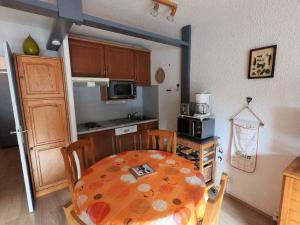 a kitchen with a table and a kitchen with a table and chairs at Studio 4 pers, centre station, proche pistes, balcon, ascenseur - FR-1-516-151 in Les Deux Alpes +2 photos