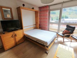 a bedroom with a bed and a tv and a chair at Studio 4 pers, centre station, proche pistes, balcon, ascenseur - FR-1-516-151 in Les Deux Alpes