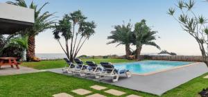 a group of chairs sitting next to a swimming pool at Exceptional villa in Vila Franca Do Campo with private pool in Vila Franca do Campo