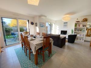 ein Esszimmer und ein Wohnzimmer mit Tisch und Stühlen in der Unterkunft MASSALINE - Jardin clos, Plage 1km - K38 in Carnac