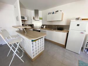 eine Küche mit Theke und weißem Kühlschrank in der Unterkunft MASSALINE - Jardin clos, Plage 1km - K38 in Carnac + 10 Fotos