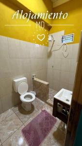 a bathroom with a white toilet and a sink at Alojamiento MD in Wanda