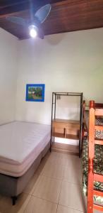 a bedroom with two bunk beds and a ceiling fan at Casa Jardim do Mar - Ubatuba - Praia Grande in Ubatuba