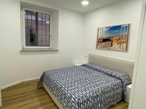 une chambre avec un lit dans une pièce avec deux fenêtres dans l'établissement Little White House Loano, à Loano