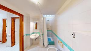 a white bathroom with a sink and a toilet at Villa Marina in Campu Longu