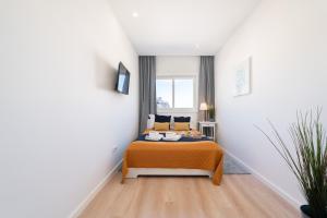 a bedroom with a bed in a white room at Bright & Spacious Retreat with Balcony by HostWise in Porto