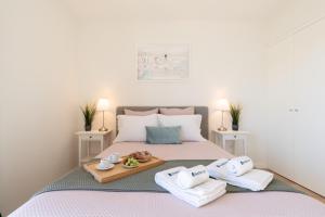 a bedroom with a bed with a tray of towels at Bright & Spacious Retreat with Balcony by HostWise in Porto
